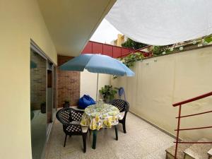 a table with a blue umbrella on a patio at Cávado Terrace Studio in Parada de Tibães