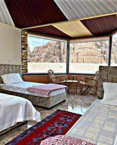 een kamer met 2 bedden en uitzicht op de woestijn bij Azeez Wadi rum in Disah
