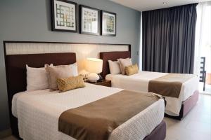 ein Hotelzimmer mit 2 Betten und einem Fenster in der Unterkunft The Inn at Mazatlan in Mazatlán