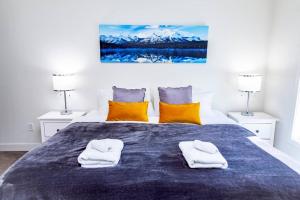 a bedroom with a bed with two towels on it at Revy Pow Pad - Private Hot Tub 3 Bedroom Condo in Revelstoke