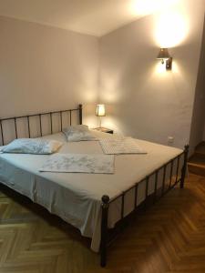 um quarto com uma cama grande e lençóis brancos em Cozy Guest House in Old Batumi em Batumi