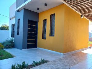 una casa amarilla y azul con una puerta en Casa Costa Sur en Posadas