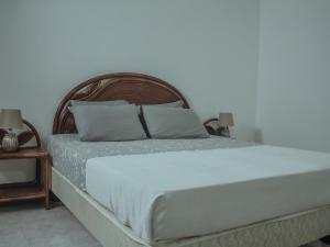 Una cama con sábanas blancas y almohadas en un dormitorio en Vila Paradise Sea & Swimming Pool View en Beirona