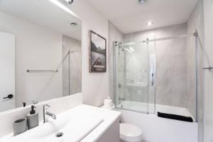 a white bathroom with a sink and a shower at Rocky Ridge Getaway - Modern Getaway in Revelstoke in Revelstoke +13 photos