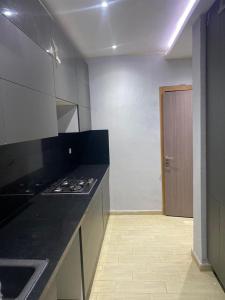 a kitchen with a black counter top and a stove at Apartment in Soukra in Tunis