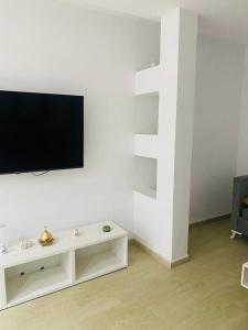 a living room with a flat screen tv on a white wall at Apartment in Soukra in Tunis