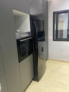 a kitchen with a black refrigerator and a window at Apartment in Soukra in Tunis