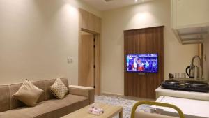 a living room with a couch and a tv at شقق برج بيات للشقق الفندقية in Jazan