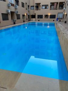 een groot blauw zwembad in een gebouw bij Luxury & cosy apartment in Marrakesh