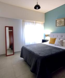 Un dormitorio con una cama grande con ventana. en Casa a tres cuadras del mar, en Puerto Madryn