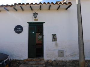 Una puerta a un edificio blanco con un cartel. en Casa Hotel Paraíso Bella Villa en Villa de Leyva