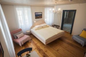 a small bedroom with a bed and a chair at Wanderlust Boutique Rooms - Self Check-in & Personal Check-in in Bad Goisern