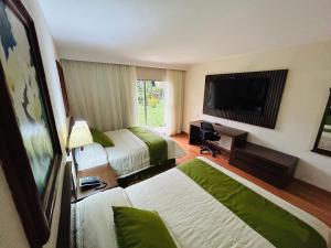 a hotel room with two beds and a flat screen tv at Hotel Villa Florida Córdoba in Córdoba
