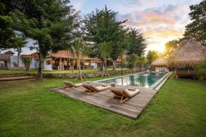 a swimming pool with lounge chairs and a resort at Bingin Villa Dedaren 4 bedrooms in Uluwatu