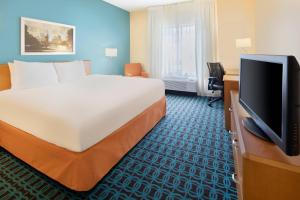 a hotel room with a bed and a flat screen tv at Fairfield Inn & Suites Austin University Area in Austin