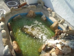 a pool of water in a container with rocks at Skyros Panorama Studios in Skiros