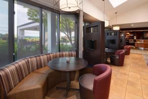 a restaurant with a couch and a table and chairs at Courtyard by Marriott Augusta in Augusta