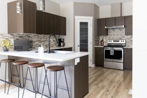 a kitchen with a white counter top and wooden cabinets at The Mackenzie Haven in Revelstoke