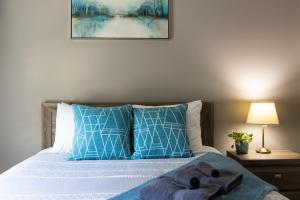 1 dormitorio con 1 cama con almohadas azules y blancas en The Mackenzie Haven en Revelstoke