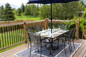 a table with chairs and an umbrella on a deck at The Mackenzie Haven in Revelstoke