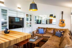 a living room with a couch and a table and a guitar at The Revelstuck Hut - Downtown Revelstoke in Revelstoke