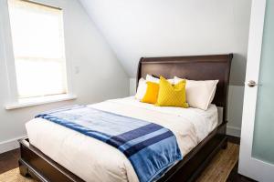 a bedroom with a bed with yellow and blue pillows at The Revelstuck Hut - Downtown Revelstoke in Revelstoke