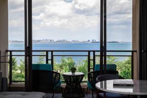Habitación con vistas al océano, sillas y mesas. en Xiamen Marriott Hotel & Conference Centre, en Xiamen