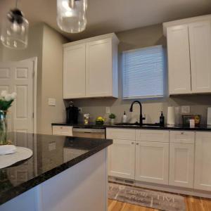a kitchen with white cabinets and a black counter top at 2 bd 2 bath in Fountain Square- 5 Min to Downtown in Indianapolis