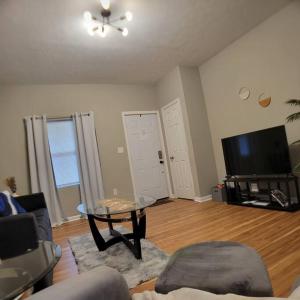 a living room with a table and a flat screen tv at 2 bd 2 bath in Fountain Square- 5 Min to Downtown in Indianapolis