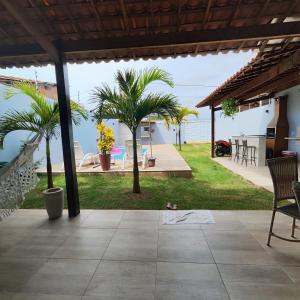 a patio with palm trees and a view of the ocean at Casa Lenger in Aracaju