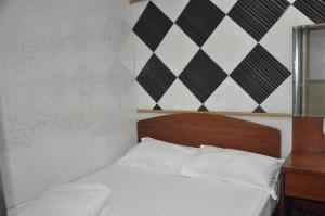 a bed with white sheets and a wooden head board at Jinhai Hotel in Hong Kong