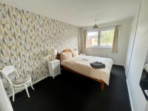 1 dormitorio con 1 cama y 1 silla en Spacious 2 double bed city home, en Hereford