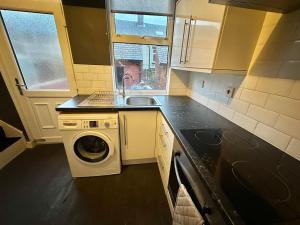 a kitchen with a washing machine and a sink at Perfect Group/Contractors Home in Barnsley