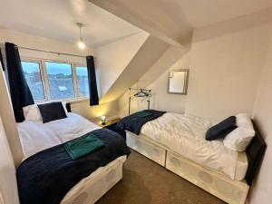 1 dormitorio con 2 camas y ventana en Perfect Group/Contractors Home en Barnsley