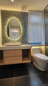 a bathroom with a sink and a toilet and a mirror at Villa NovawoRld Phan Thiết in Bình Sum