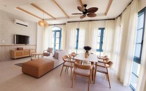 a living room with a table and chairs and a couch at Villa NovawoRld Phan Thiết in Bình Sum