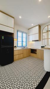 a kitchen with a black and white tiled floor at Villa NovawoRld Phan Thiết in Bình Sum