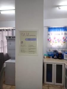 Roseau City Hub Apartment في روسو: مطبخ مع ثلاجة مع علامة على الحائط