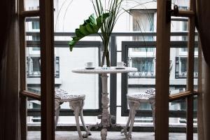 una mesa con 2 sillas frente a una ventana en Ulises Recoleta Suites, en Buenos Aires