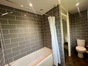 a bathroom with a white tub and a toilet at Spacious 2 double bed city home in Hereford