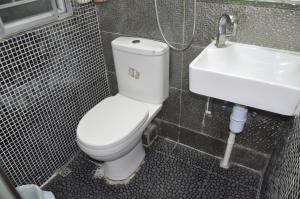 a bathroom with a white toilet and a sink at Jinhai Hotel in Hong Kong