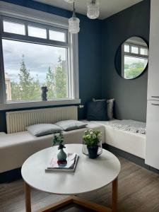 uma sala de estar com um sofá e uma mesa em Lovely Penthouse downtown with 3 bedrooms em Akureyri