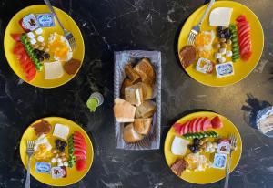 a table topped with yellow plates of food with different foods at OTTOMAN İSTANBUL AİRPORT OTEL in Istanbul