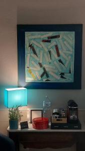un tavolo con un dipinto sul muro e una lampada di H22 Hotel a Napoli