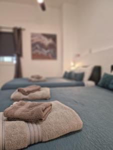 twee handdoeken zitten bovenop een bed bij Royal Stay Luxury Homes in Paphos City
