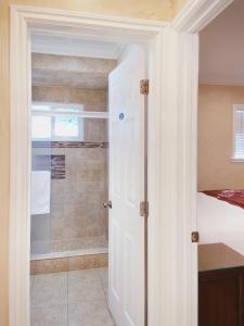 a bathroom with a walk in shower next to a door at Nite Inn at Universal City - Walking Distance to Universal Studios Hollywood in Los Angeles