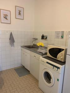 una cucina con lavatrice e forno a microonde di La Casetta di Piero by SMART-HOME a Genova