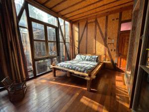 a room with a bench in a room with windows at PazZHOtel in Valparaíso