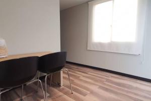 Pokój ze stołem, 2 krzesłami i białą ścianą w obiekcie Apartaestudio independiente y amplia Chía w mieście Chía