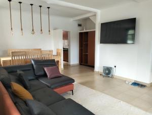 een woonkamer met een bank en een flatscreen-tv bij Diani Hideaway Beach Villa in Galu